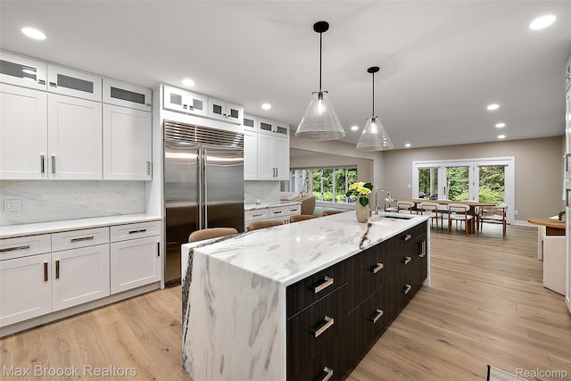 3546 Bloomfield Club Dr, Bloomfield Hills, MI 48301 - kitchen with stainless steel built in refrigerator, white cabinets, a kitchen island with sink, tasteful backsplash, and recessed lighting