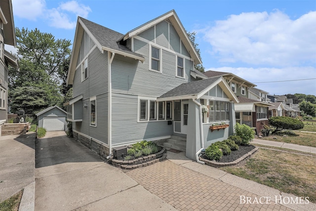 1035 Fountain St NE, Grand Rapids, MI 49503 - view of front of home with entry steps, driveway, roof with shingles, an outdoor structure, and a garage