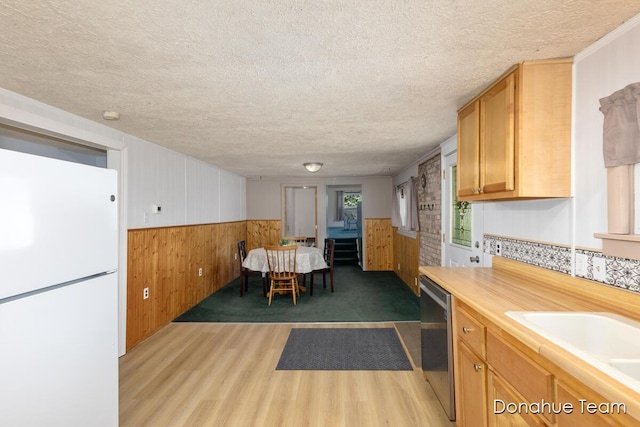 4875 Ferris Ave, Newaygo, MI 49337 - kitchen with freestanding refrigerator, wooden walls, light wood-type flooring, a textured ceiling, and dishwasher