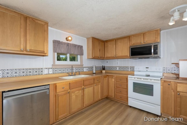 4875 Ferris Ave, Newaygo, MI 49337 - kitchen with stainless steel appliances, light wood-style floors, light countertops, a textured ceiling, and ornamental molding