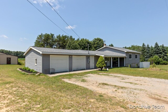 4875 Ferris Ave, Newaygo, MI 49337 - view of front facade featuring dirt driveway, an attached garage, and a front lawn