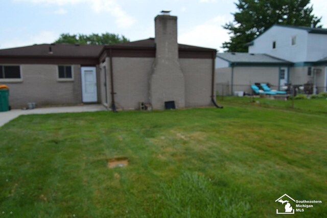 27354 Oakcrest Dr, Brownstown, MI 48183 - rear view of property with a chimney and a lawn