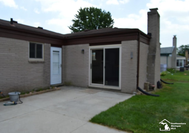 27354 Oakcrest Dr, Brownstown, MI 48183 - back of property featuring brick siding, a patio area, a yard, and a chimney