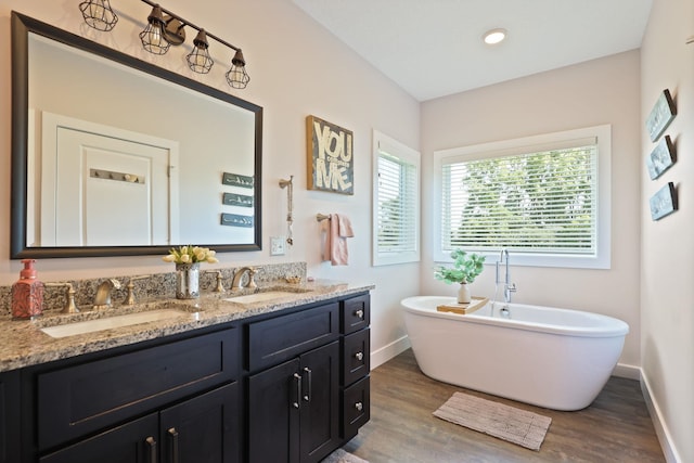 12529 E Tuscola Rd, Frankenmuth, MI 48734 - full bathroom featuring wood finished floors, double vanity, a freestanding tub, and recessed lighting