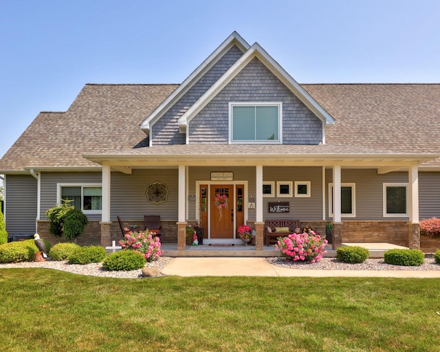 12529 E Tuscola Rd, Frankenmuth, MI 48734 - craftsman-style home featuring a front yard, roof with shingles, a porch, and stone siding