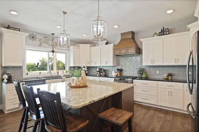 12529 E Tuscola Rd, Frankenmuth, MI 48734 - kitchen featuring premium range hood, appliances with stainless steel finishes, white cabinetry, backsplash, and a center island