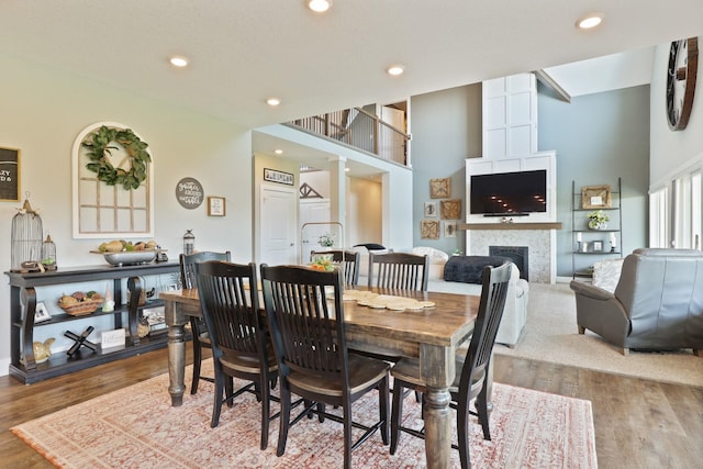 12529 E Tuscola Rd, Frankenmuth, MI 48734 - dining space featuring a fireplace, wood finished floors, a towering ceiling, and recessed lighting
