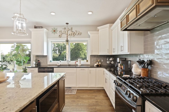 12529 E Tuscola Rd, Frankenmuth, MI 48734 - kitchen featuring stainless steel appliances, under cabinet range hood, dark stone counters, pendant lighting, and decorative backsplash
