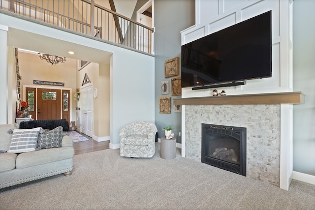 12529 E Tuscola Rd, Frankenmuth, MI 48734 - living area with a high ceiling, carpet, a tiled fireplace, and a chandelier