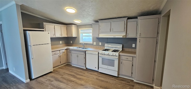 7102 Highlander Cir, Alma, MI 48801 - kitchen featuring white appliances, lofted ceiling, a textured ceiling, light countertops, and range hood