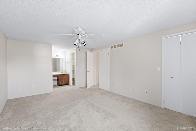 20918 W Glen Haven Cir, Novi, MI 48167 - unfurnished bedroom featuring two closets, light colored carpet, ensuite bath, a textured ceiling, and ceiling fan