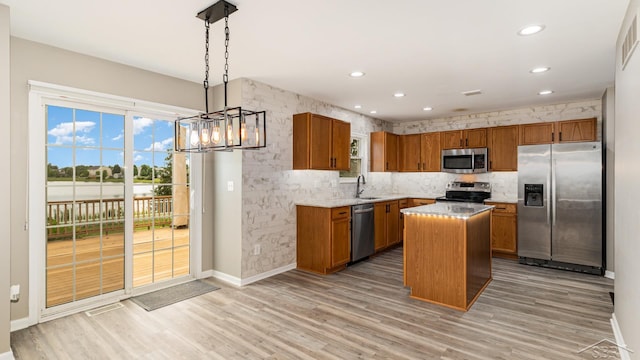 3244 Pine Run Dr, Swartz Creek, MI 48473 - kitchen with stainless steel appliances, brown cabinetry, light wood finished floors, hanging light fixtures, and recessed lighting