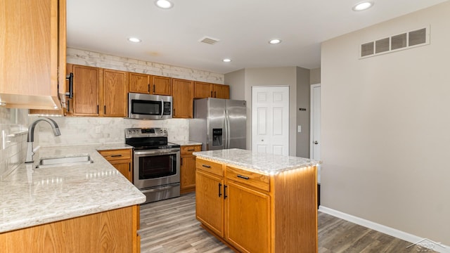 3244 Pine Run Dr, Swartz Creek, MI 48473 - kitchen featuring appliances with stainless steel finishes, decorative backsplash, light wood-style floors, recessed lighting, and a center island