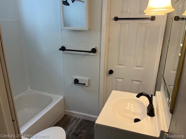1147 Norton St, Flint, MI 48529 - bathroom featuring wood finished floors, vanity, and shower / tub combination