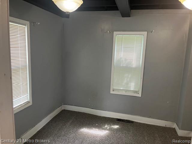 1147 Norton St, Flint, MI 48529 - carpeted spare room with beamed ceiling and baseboards