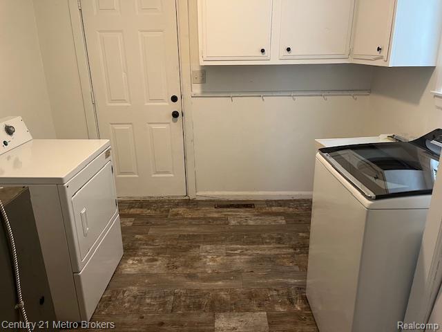 1147 Norton St, Flint, MI 48529 - laundry area with washer and dryer, dark wood-style flooring, and cabinet space
