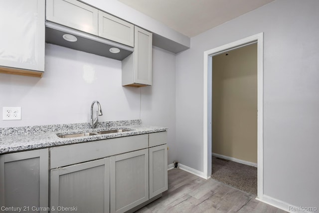 20510 Rosemont Ave, Detroit, MI 48219 - kitchen featuring light wood-style floors, light stone countertops, and gray cabinetry