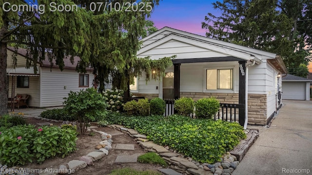 7536 Arcola St, Westland, MI 48185 - view of front of property with stone siding, covered porch, and a detached garage