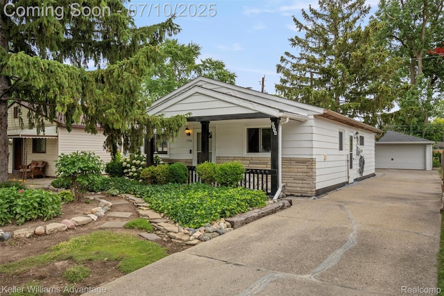 7536 Arcola St, Westland, MI 48185 - view of front facade featuring a porch, a detached garage, stone siding, and an outbuilding