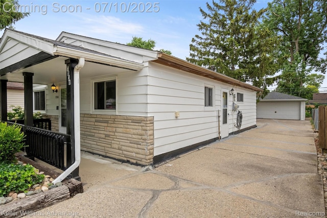 7536 Arcola St, Westland, MI 48185 - view of side of property with a detached garage, a porch, an outdoor structure, and stone siding