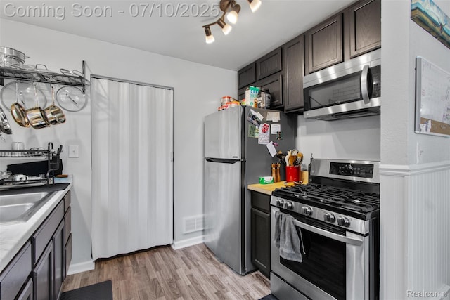 6336 Glenis St, Taylor, MI 48180 - kitchen with appliances with stainless steel finishes, light countertops, light wood finished floors, and dark brown cabinetry
