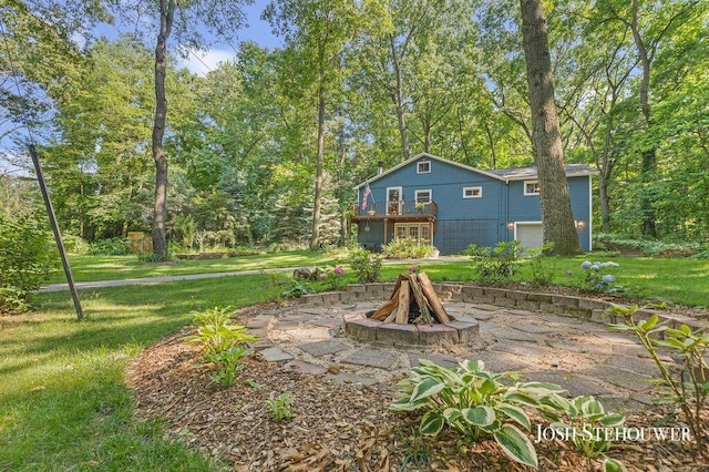 678 Pierce Rd, Plainwell, MI 49080 - rear view of house featuring a lawn, a fire pit, a wooden deck, and an attached garage