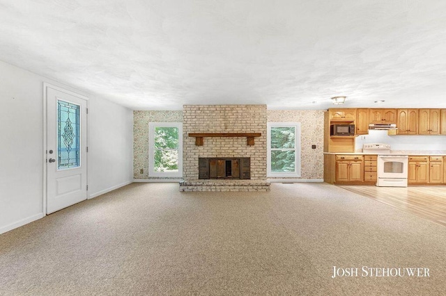678 Pierce Rd, Plainwell, MI 49080 - unfurnished living room featuring light colored carpet and a fireplace