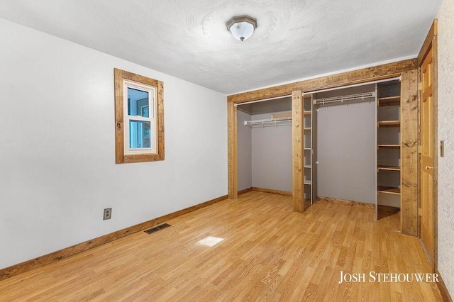 678 Pierce Rd, Plainwell, MI 49080 - unfurnished bedroom featuring two closets and wood finished floors