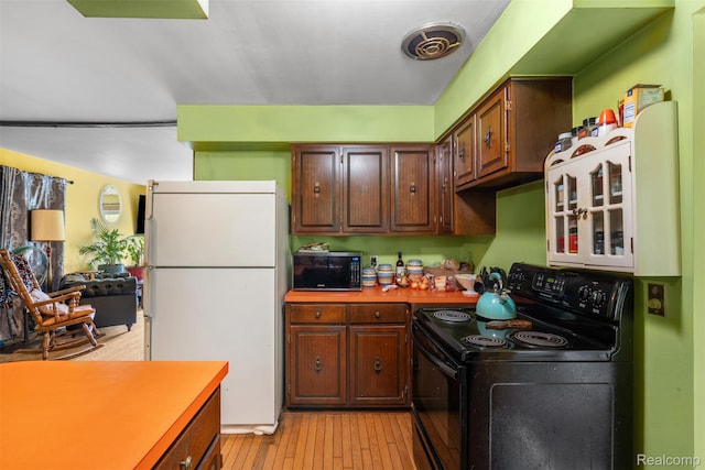 2650 N Lake George Rd, Metamora, MI 48455 - kitchen featuring black appliances, light countertops, and light wood-type flooring