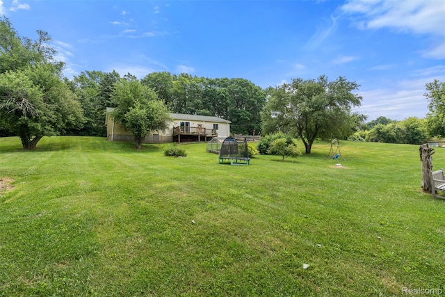 2650 N Lake George Rd, Metamora, MI 48455 - view of green lawn featuring a trampoline and a wooden deck