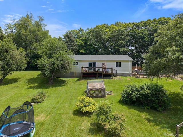 2650 N Lake George Rd, Metamora, MI 48455 - back of property with a wooden deck, a yard, and a trampoline