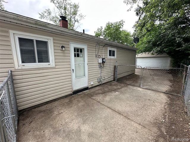 18455 Centralia, Redford, MI 48240 - back of property with a chimney, a patio area, an outbuilding, and a gate