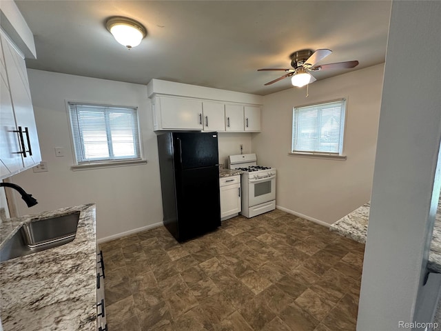 18455 Centralia, Redford, MI 48240 - kitchen with freestanding refrigerator, white gas stove, light stone countertops, ceiling fan, and white cabinetry