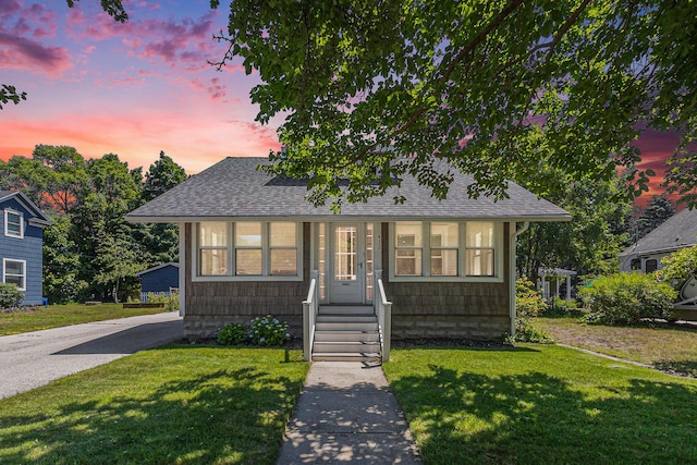 412 N Robert St, Ludington, MI 49431 - bungalow with a shingled roof and a yard