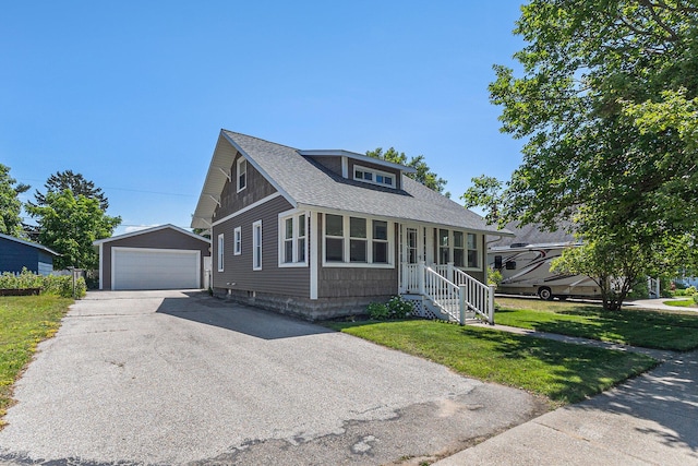 412 N Robert St, Ludington, MI 49431 - bungalow with an outbuilding, a detached garage, roof with shingles, and a front lawn