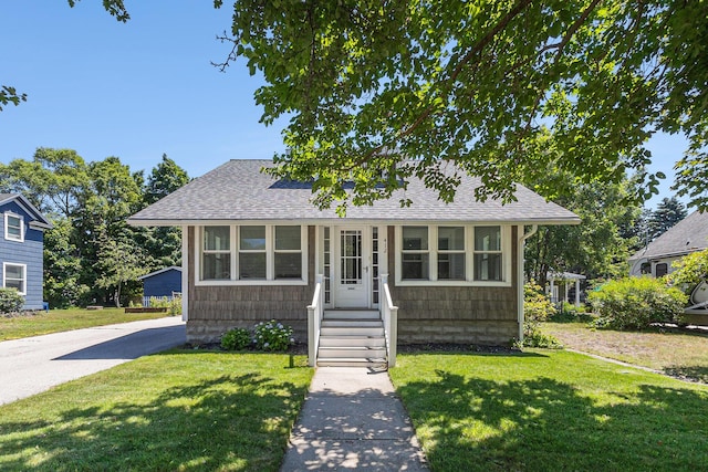 412 N Robert St, Ludington, MI 49431 - view of front of property featuring a shingled roof and a front yard