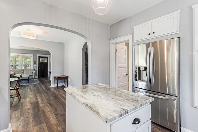 412 N Robert St, Ludington, MI 49431 - kitchen featuring stainless steel refrigerator with ice dispenser, arched walkways, a kitchen island, and light stone countertops