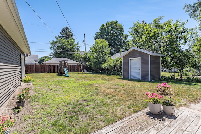 412 N Robert St, Ludington, MI 49431 - fenced backyard featuring a playground, a storage unit, and a wooden deck