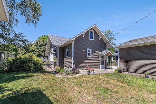 412 N Robert St, Ludington, MI 49431 - rear view of house featuring a lawn and a patio
