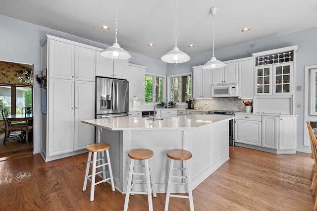 630 N 2nd St, Kalamazoo, MI 49009 - kitchen featuring stainless steel appliances, a breakfast bar, decorative backsplash, healthy amount of natural light, and recessed lighting