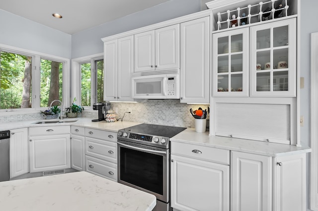 630 N 2nd St, Kalamazoo, MI 49009 - kitchen featuring white microwave, stainless steel electric range, white cabinetry, and glass insert cabinets