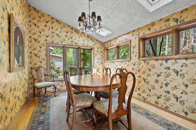 630 N 2nd St, Kalamazoo, MI 49009 - dining room featuring wallpapered walls, a skylight, vaulted ceiling, a textured ceiling, and light wood-style floors