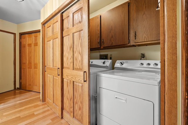 630 N 2nd St, Kalamazoo, MI 49009 - laundry room featuring cabinet space, washing machine and dryer, and light wood-style flooring