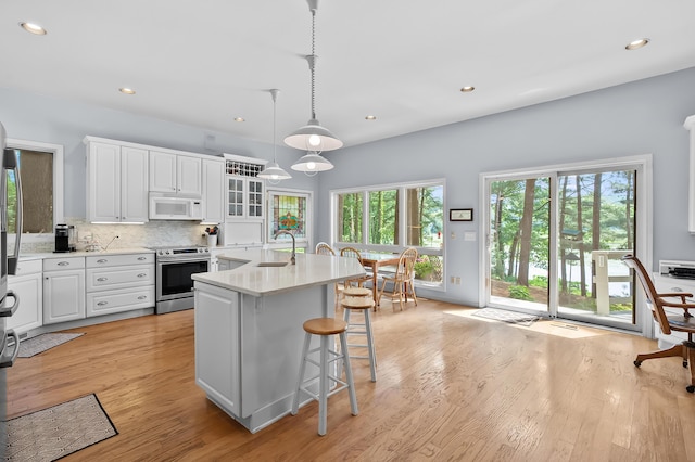 630 N 2nd St, Kalamazoo, MI 49009 - kitchen with stainless steel electric range oven, white microwave, light countertops, white cabinetry, and recessed lighting