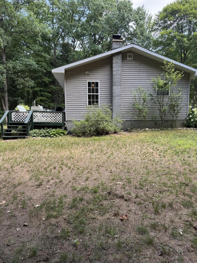 17924 Round Lake Rd, Wellston, MI 49689 - view of home's exterior with a chimney and a lawn
