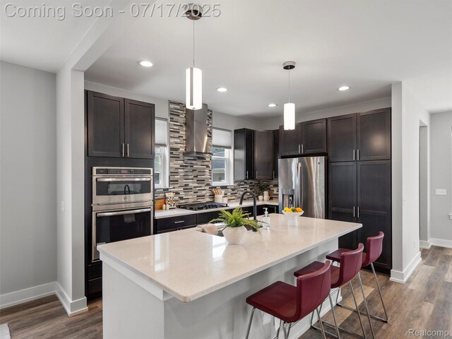 482 Wilson St, Ferndale, MI 48220 - kitchen with appliances with stainless steel finishes, wall chimney exhaust hood, tasteful backsplash, dark wood-style flooring, and recessed lighting