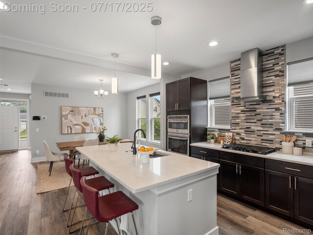 482 Wilson St, Ferndale, MI 48220 - kitchen with double oven, wall chimney exhaust hood, backsplash, recessed lighting, and gas stovetop