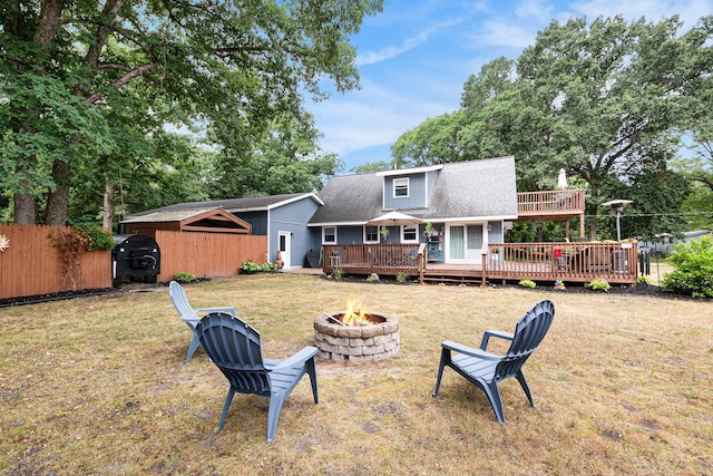 2430 140th Ave, Dorr, MI 49323 - rear view of house featuring an outdoor fire pit, a wooden deck, and a shingled roof