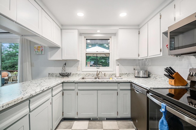 2430 140th Ave, Dorr, MI 49323 - kitchen with stainless steel appliances, decorative backsplash, white cabinetry, light stone countertops, and recessed lighting