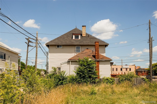 1525 Spruce St, Detroit, MI 48216 - back of house with a chimney and roof with shingles